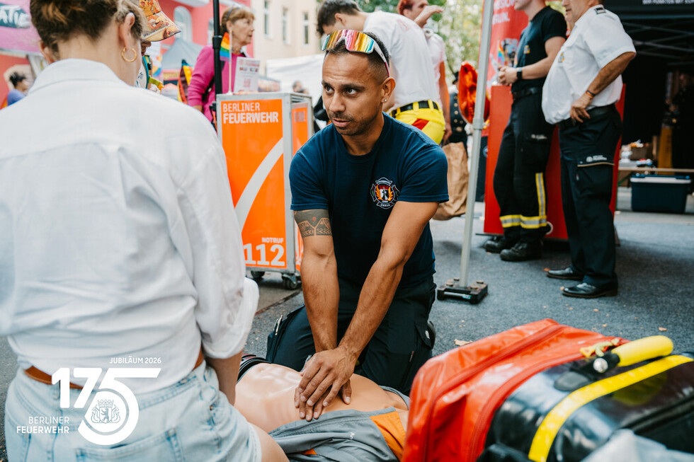 Mitarbeitende der Berliner Feuerwehr zeigen Besucherinnen und Besuchern die Grundlagen der Herzdruckmassage.