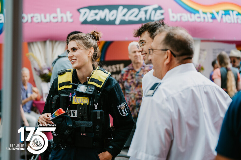 Einsatzkräfte der Polizei Berlin am Informationsstand der Berliner Feuerwehr.