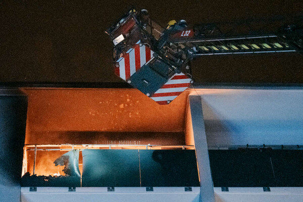 Korb einer Drehleiter vor brennendem Balkon