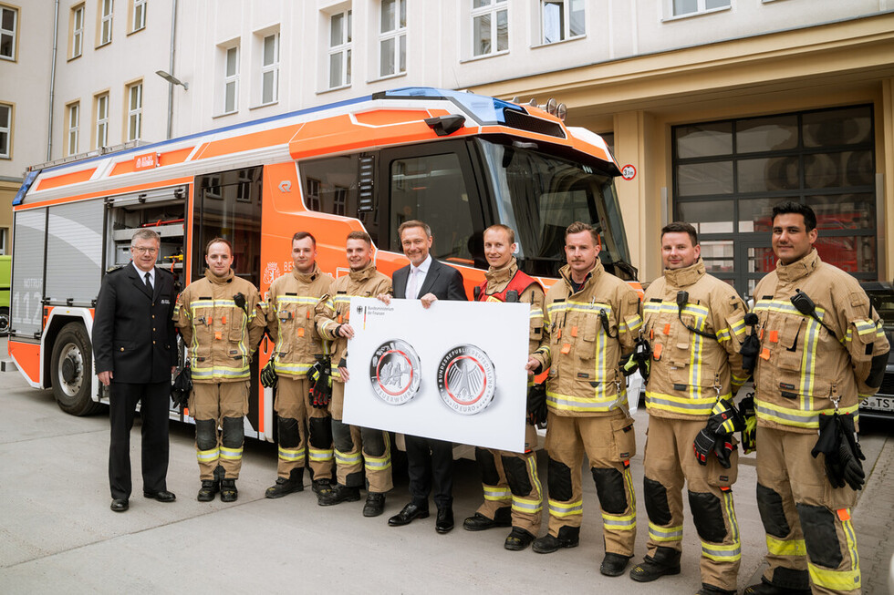 Dr. Homrighausen, Feuerwehrangehörige und Herr Lindner bei der Münzübergabe