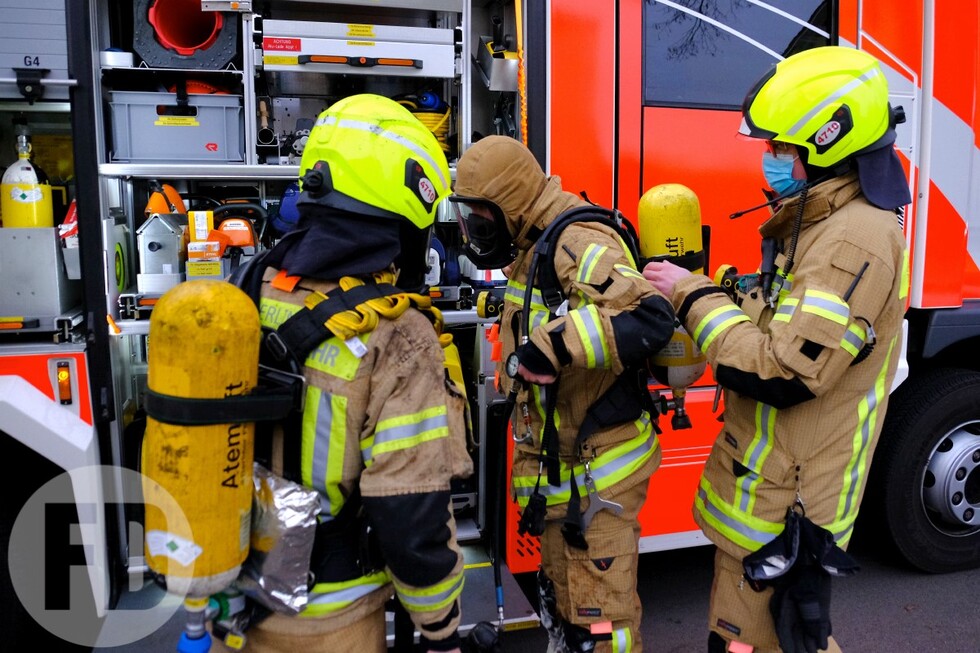 Einsatzkräfte rüsten sich für die Brandbekämpfung aus.