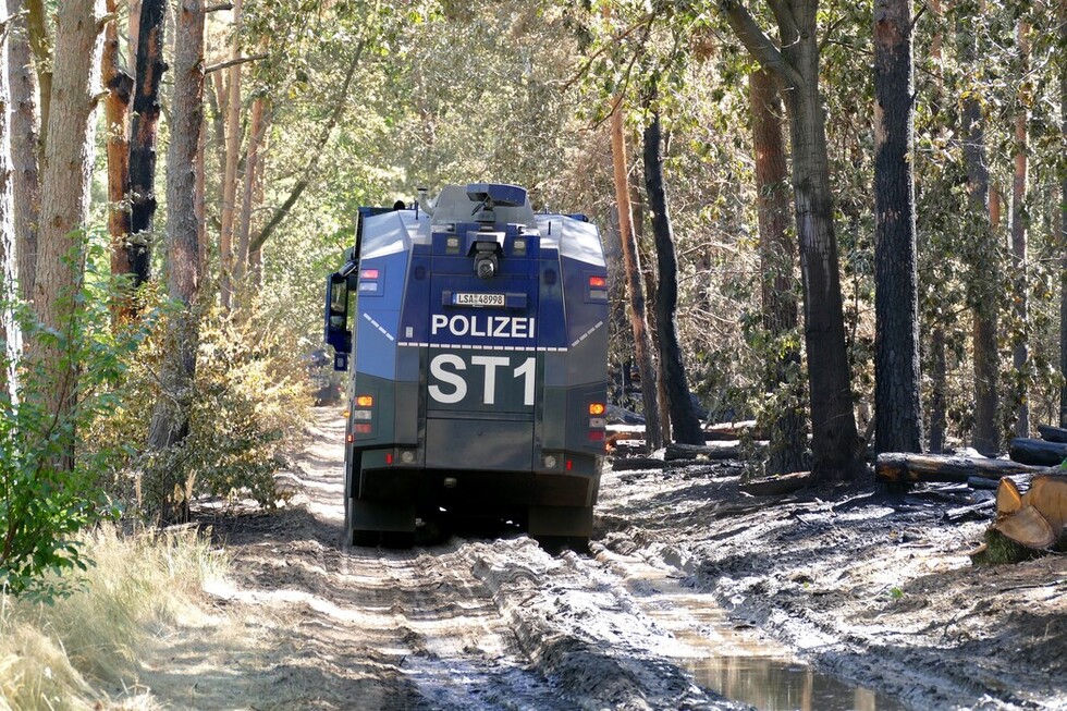 Wasserwerfer der Polizei im Waldgebiet nahe des Sprengplatzes.
