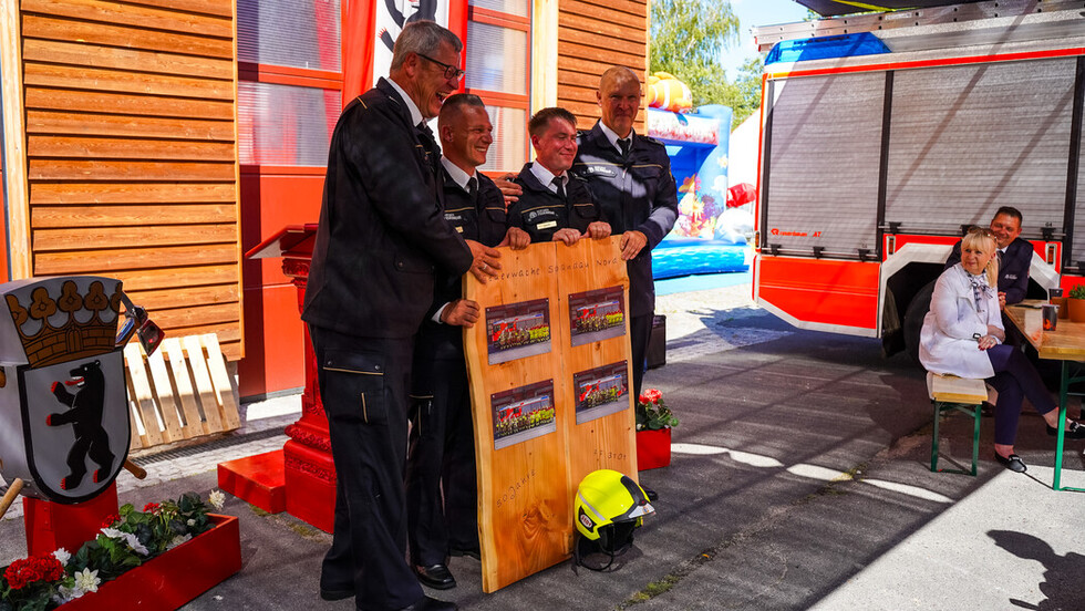 Übergabe eines Geschenkes durch den Betreuungswachleiter der FF Spandau-Nord (Wachleiter der Feuerwache Spandau-Nord) und den Vertreter des Leiters vom Einsatzabschnitt 3 (Spandau, Charlottenburg-Wilmersdorf)