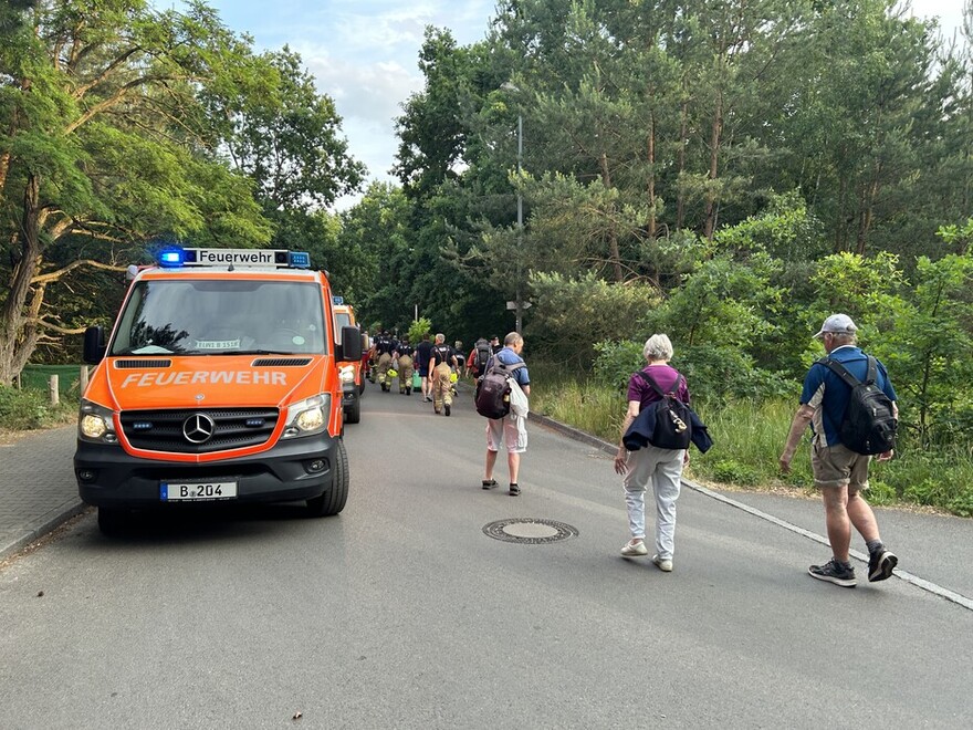 Einsatzfahrzeuge und Fahrgäste neben der Bahnstrecke in Nähe des FEZ