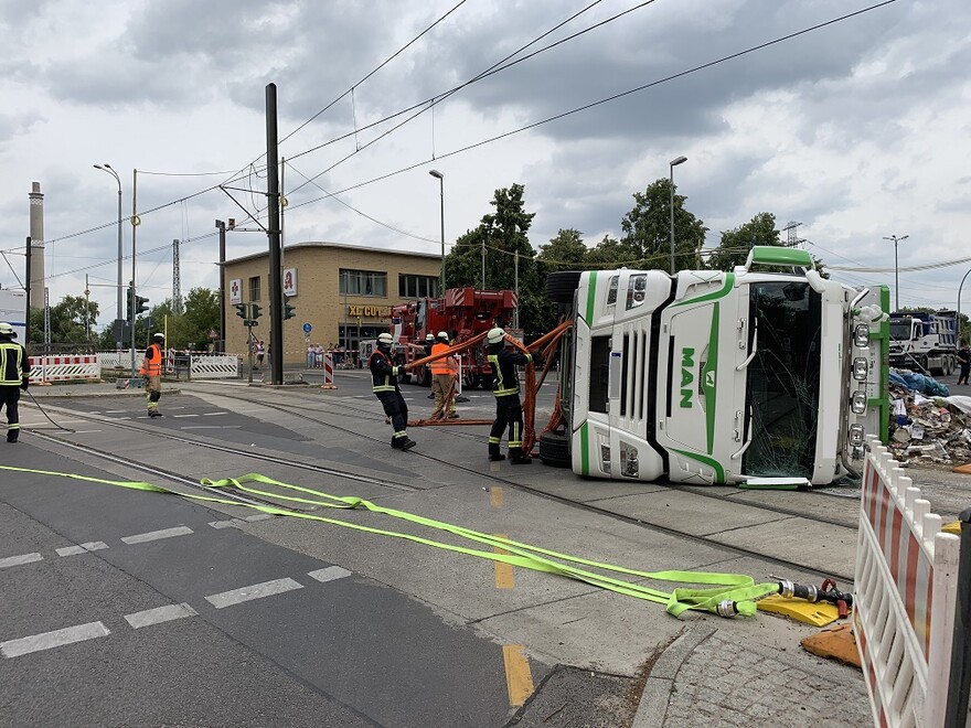 Auf der Seite liegender Lkw und erste Bergungmaßnahmen