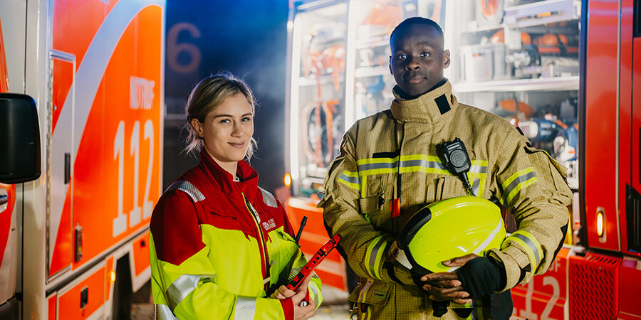 Feuerwehrleute stehen vor Einsatzfahrzeug