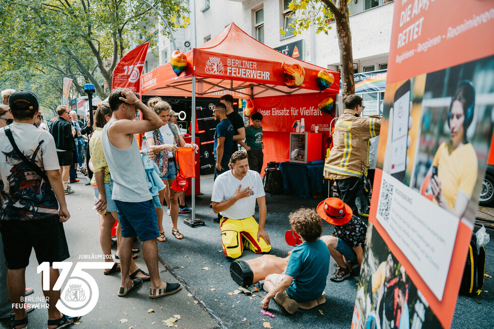 Mitarbeitende der Berliner Feuerwehr und Besucherinnen und Besucher am Informationsstand der Berliner Feuerwehr.