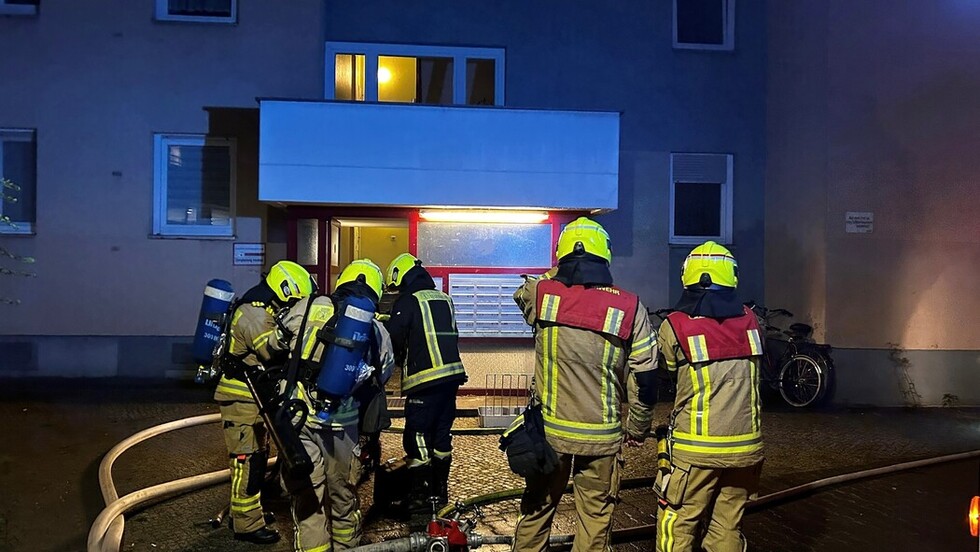 Einsatzkräfte stehen vor dem Gebäude bereit