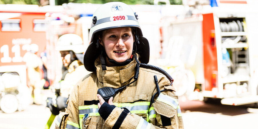 Frau in Schutzkleidung mit Helm