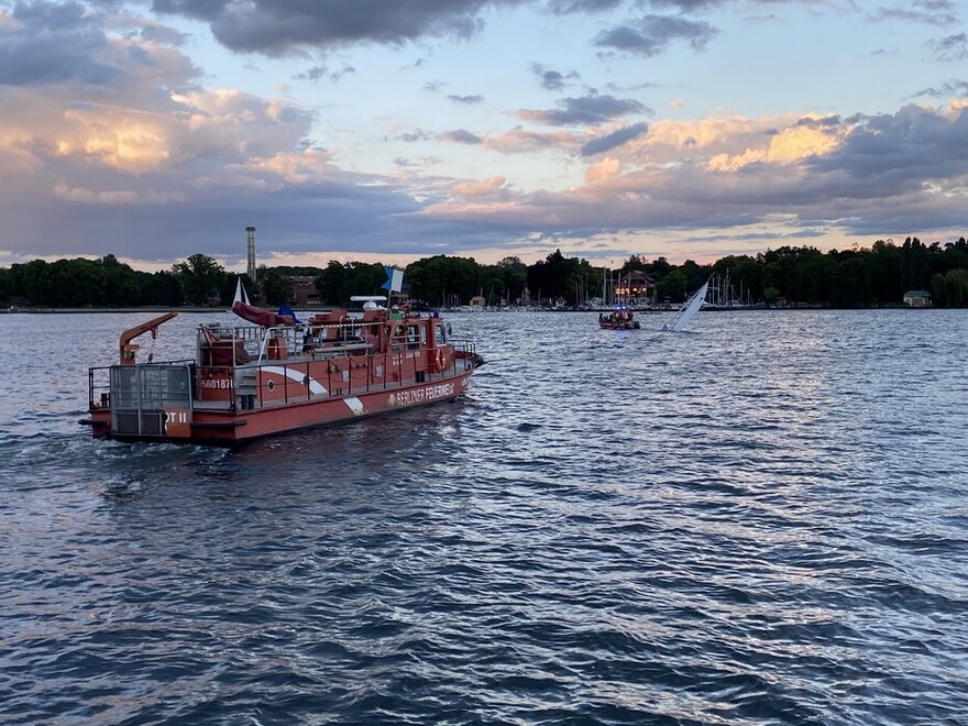 Gekentertes Segelboot wird vom Mehrzweckboot geschleppt; Löschboot unterstützt