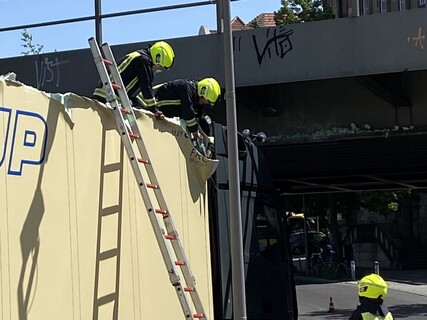 Einsatzkräfte bearbeiten das Dach des Sattelaufliegers