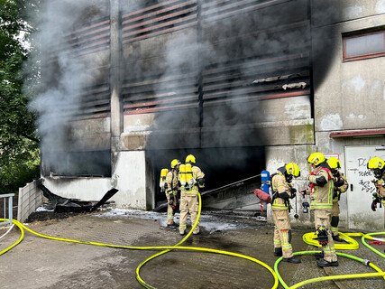 Einsatzkräfte bei der Brandbekämpfung an der Zufahrt zum Parkhaus. 