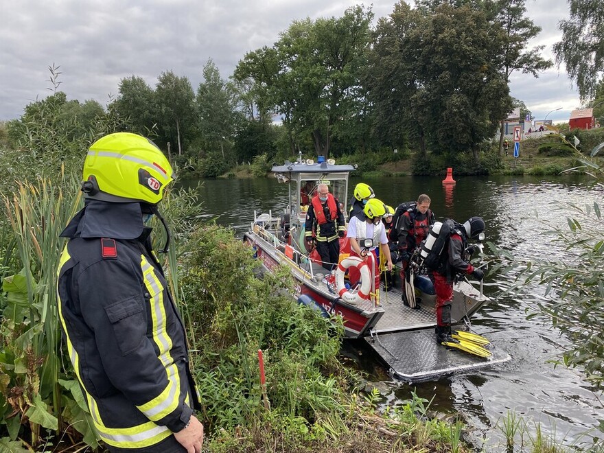 Feuerwehrtaucher werden vom Mehrzweckboot an Land gebracht