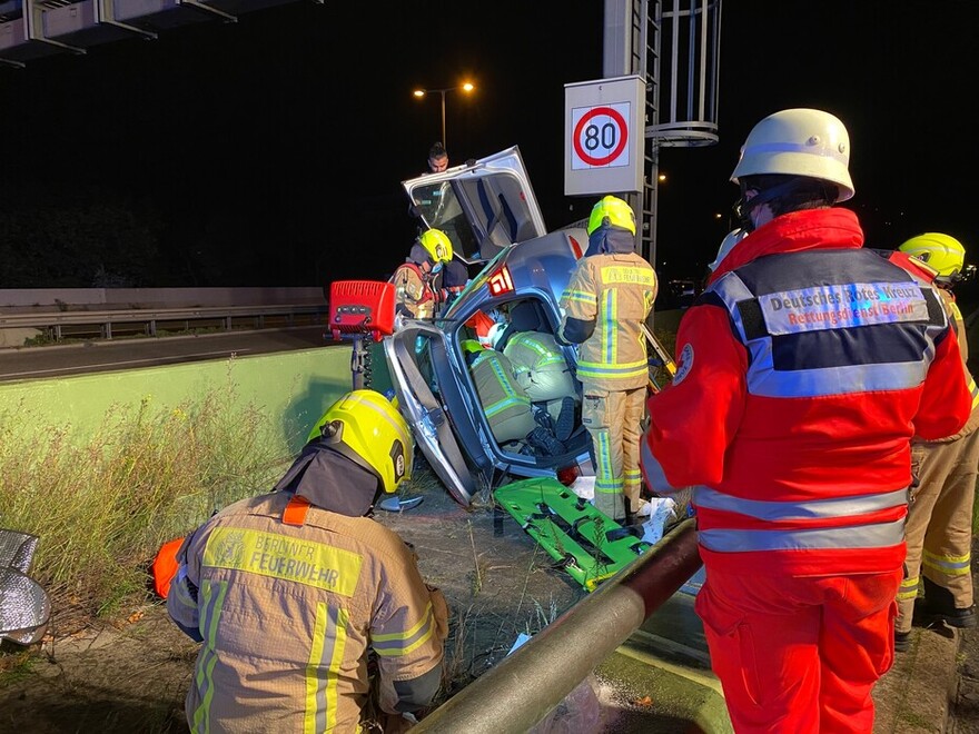 Einsatzkräfte des Technischen Dienstes verschaffen sich im inneren des Fahrzeuges einen Rettungszugang zum Patienten