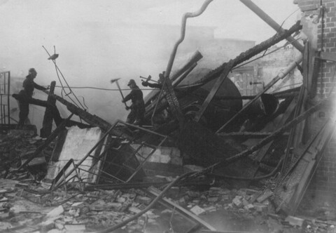 Zwei Feuerwehrleute arbeiten in der Ruine