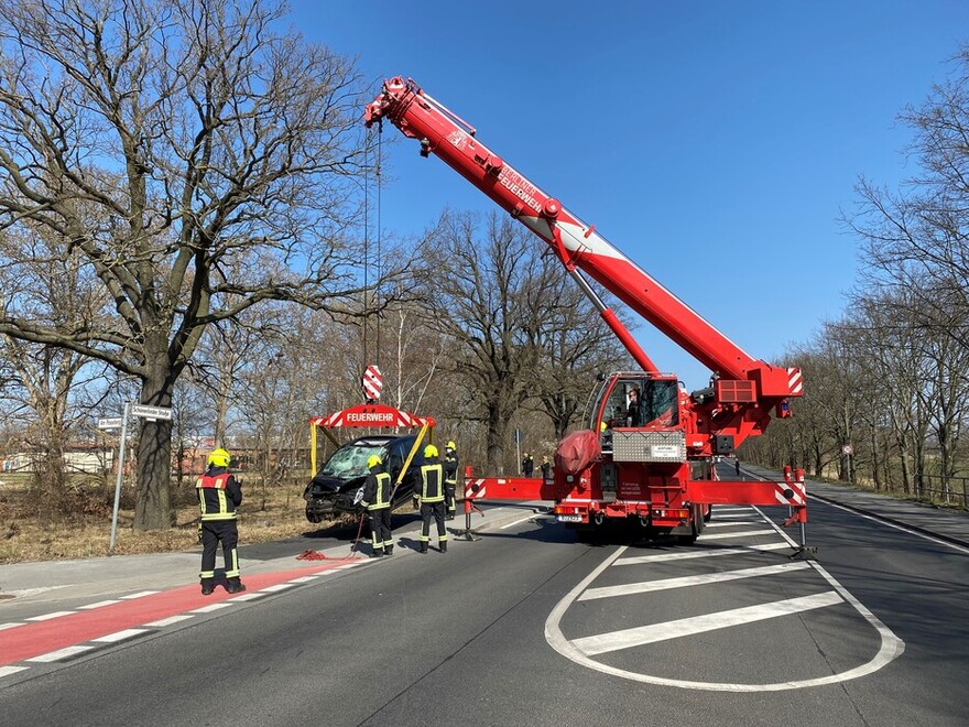 Kran setzt das verunfallte Fahrzeug auf dem Gehweg ab.