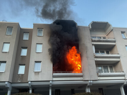 Flammen schlagen weit aus dem Balkon