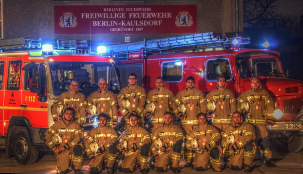 Gruppenbild Feuerwehrleute vor Fahrzeugen