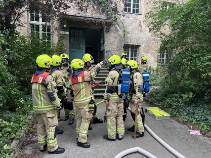 Einsatzkräfte stehen vor dem Gymnasium bereit