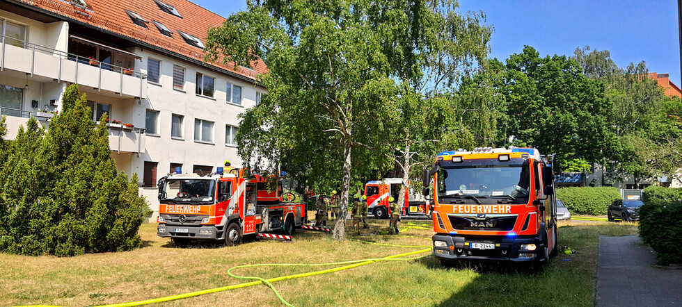 Fahrzeuge auf der Gebäuderückseite.