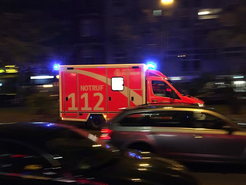 Ein Rettungswagen mit Blaulicht im nächtlichen Stadtverkehr