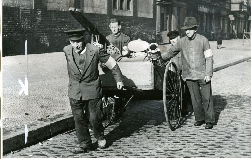 Feuerwehrleute mit Löschkarren im Jahr 1945
