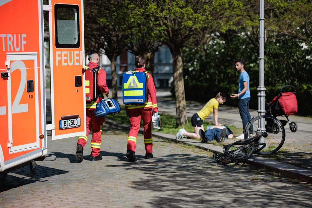 Einsatzkräfte des Rettungsdienstes laufen zu einem Notfallort