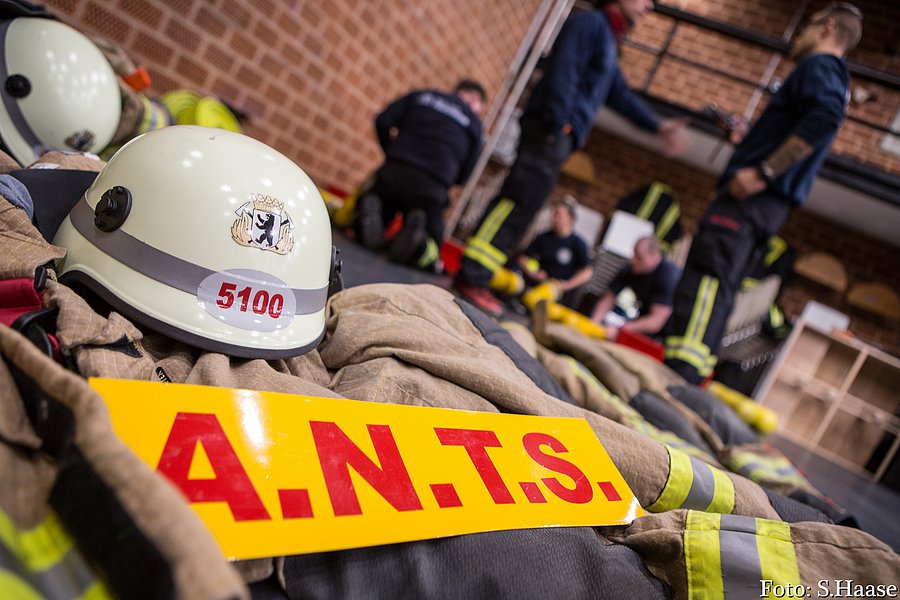 Einsatzkleidung mit Schild A.N.T.S. und Feuerwehrhelm