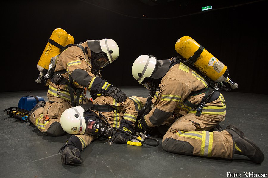 Drei Einsatzkräfte in Schutzkleidung