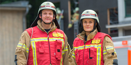 Einsatzleiterin und Einsatzleiter mit Helm und roter Weste