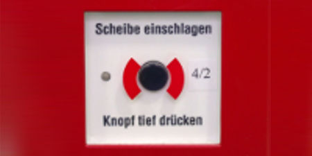 Feuermelder mit Aufschrift Scheibe einschlagen Knopf tief drücken