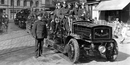 Elektrische Löschfahrzeuge mit Feuerwehrleuten im Jahr 1910
