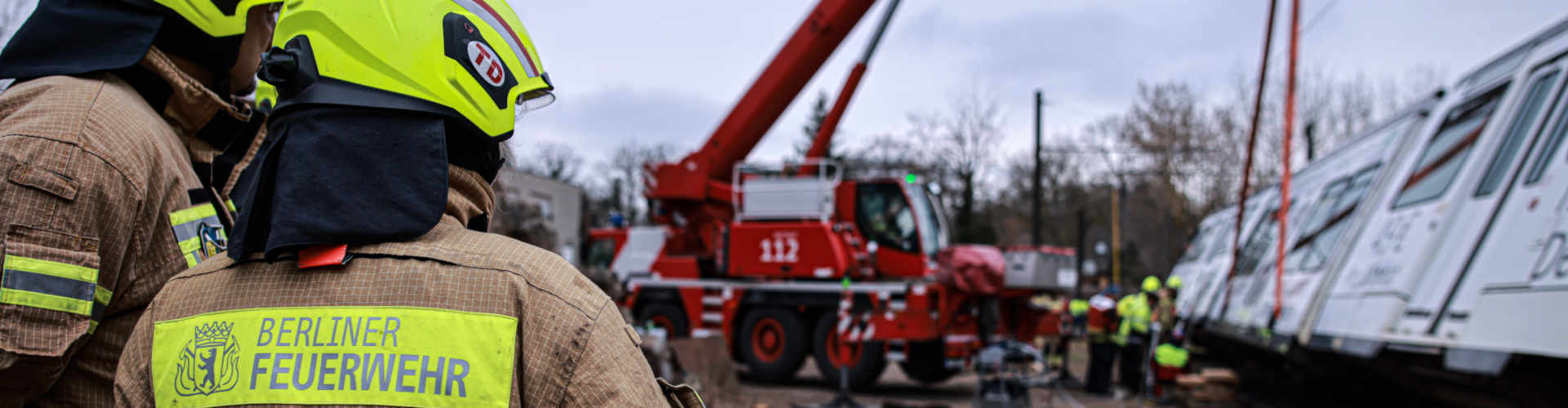 2 Feuerwehrleute vor Feuerwehrkran