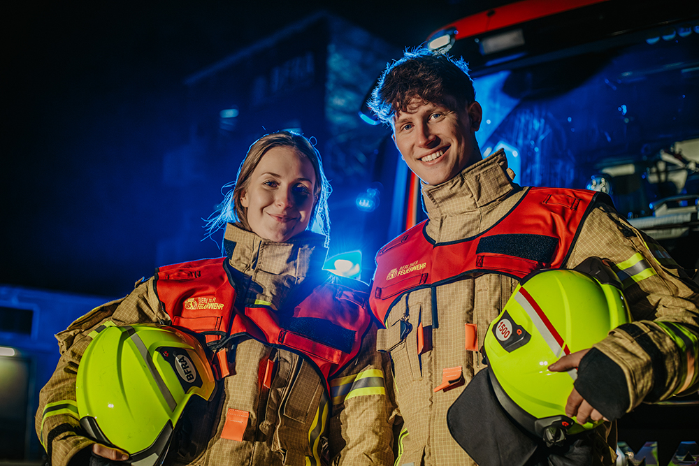 2 Führungskräfte stehen vor einem Löschfahrzeug