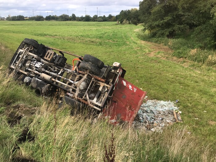 Buch: Umgekippter LKW liegt auf der Böschung.