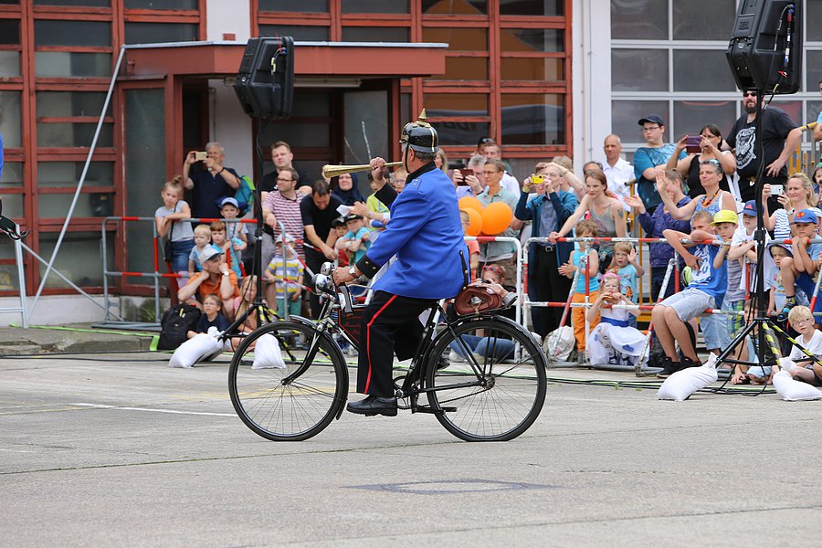 Feuerwehrmann in historischer Uniform auf Oldtimerfahrrad